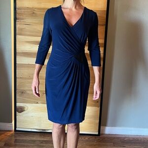 Deep blue faux wrap dress with faux leather detailing on one side.